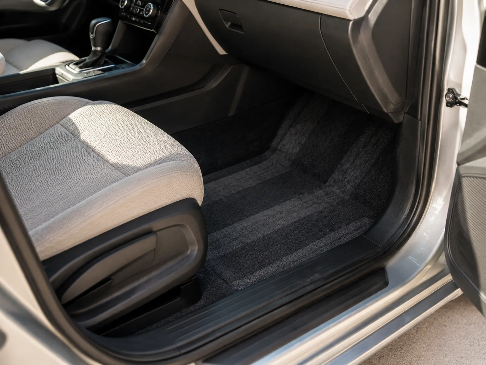 A car footwell and seat being vacuumed